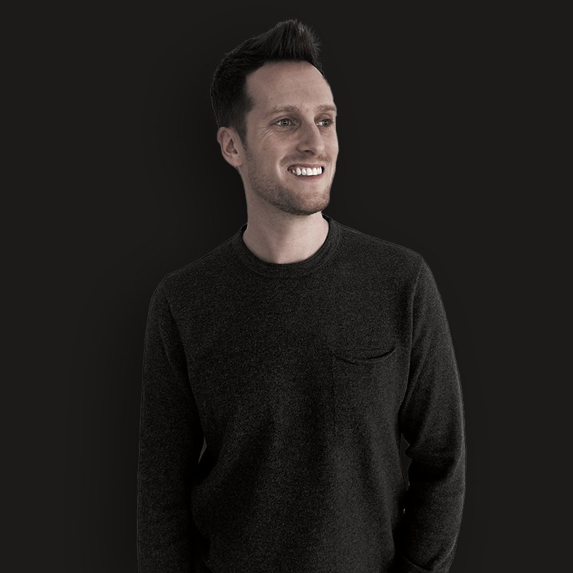 Portrait of Ben smiling, wearing a dark sweater